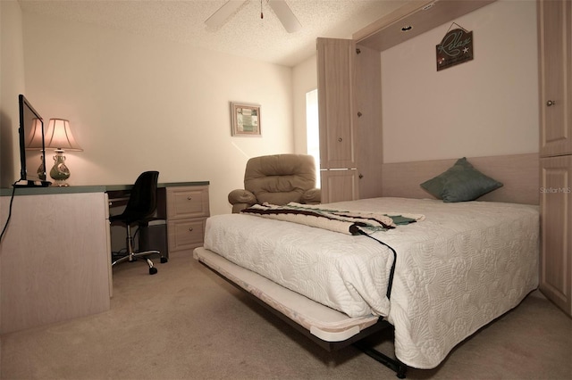 carpeted bedroom featuring ceiling fan and a textured ceiling