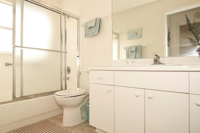 full bathroom with bath / shower combo with glass door, vanity, toilet, and tile patterned floors