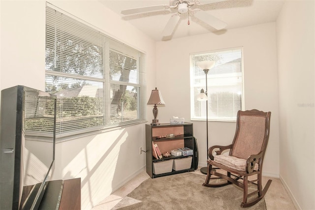 living area with light carpet, ceiling fan, and a wealth of natural light