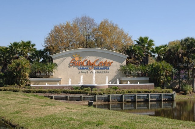 community / neighborhood sign with a water view and a yard