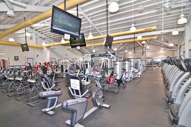 gym featuring ceiling fan and a towering ceiling