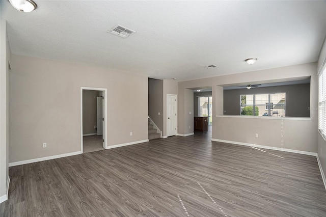 unfurnished room with dark wood-type flooring, ceiling fan, and a textured ceiling