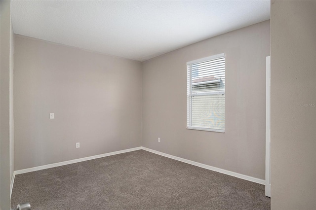 unfurnished room featuring dark carpet