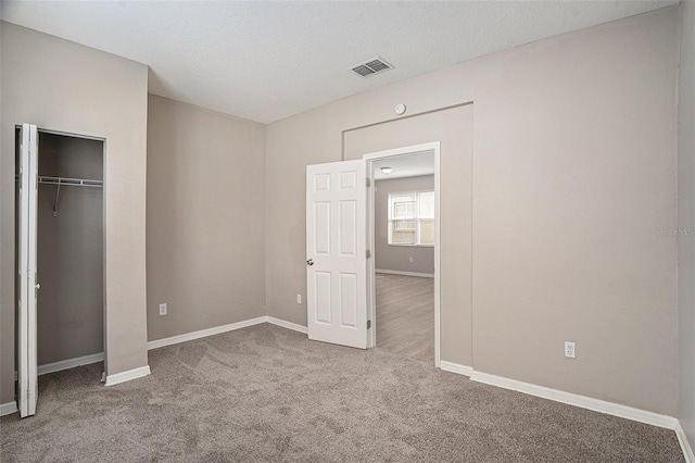 unfurnished bedroom with a closet, carpet floors, and a textured ceiling