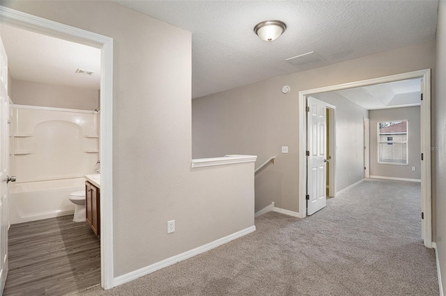 hall with carpet and a textured ceiling