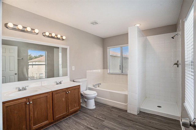 full bathroom featuring vanity, toilet, hardwood / wood-style flooring, and a wealth of natural light