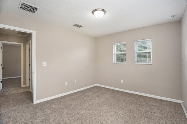 spare room with a textured ceiling and carpet