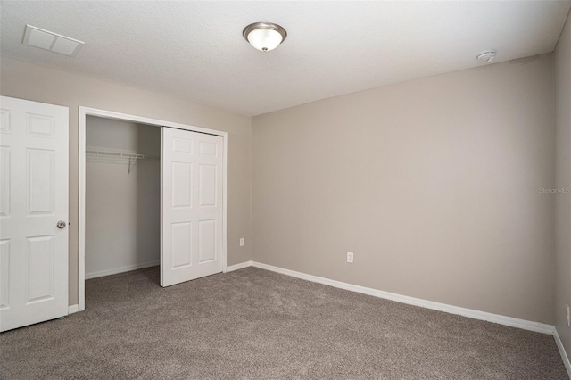 unfurnished bedroom featuring a closet, carpet flooring, and a textured ceiling