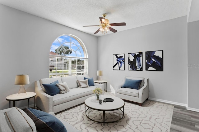 living room featuring a textured ceiling, hardwood / wood-style flooring, and ceiling fan