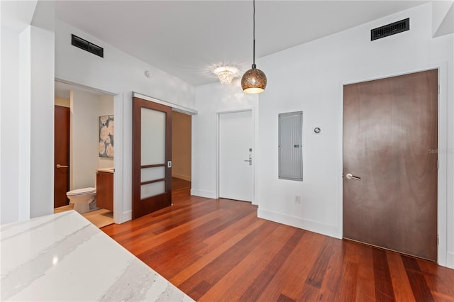 interior space with electric panel, dark hardwood / wood-style floors, and ensuite bathroom