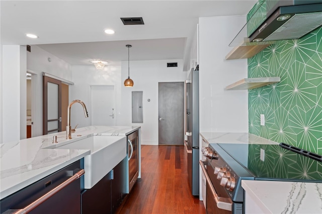 kitchen featuring hanging light fixtures, light stone counters, premium appliances, dark hardwood / wood-style flooring, and sink