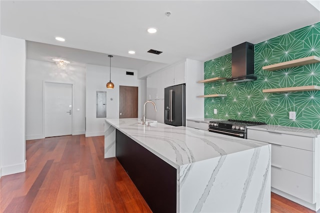 kitchen with wood-type flooring, white cabinets, stainless steel appliances, and hanging light fixtures