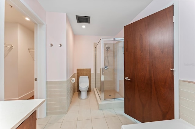 bathroom featuring vanity, toilet, tile patterned floors, and a shower with shower door