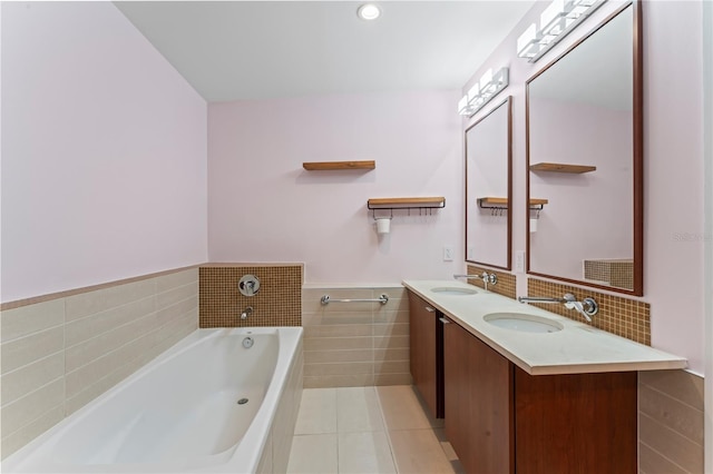 bathroom with tile walls, vanity, tile patterned floors, and a tub