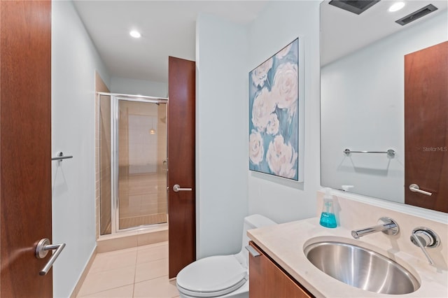 bathroom featuring a shower with door, toilet, vanity, and tile patterned floors