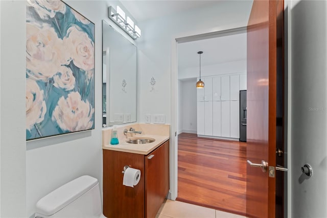 bathroom featuring vanity, hardwood / wood-style floors, and toilet