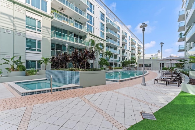 view of swimming pool with a patio and a community hot tub