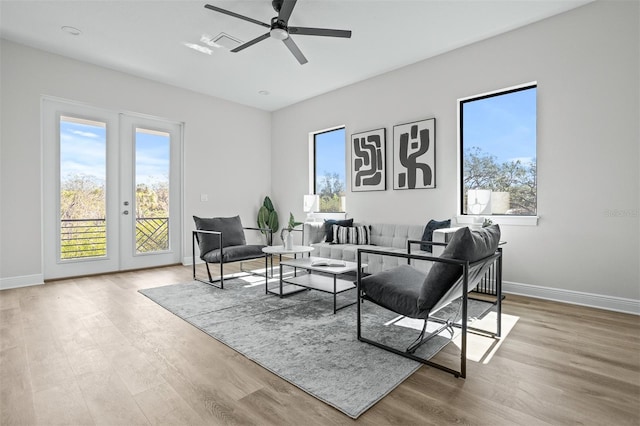 living room with french doors, light wood-type flooring, and a wealth of natural light