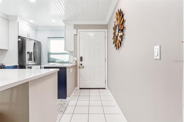 kitchen featuring stainless steel fridge, wooden ceiling, ornamental molding, white cabinets, and light tile patterned floors