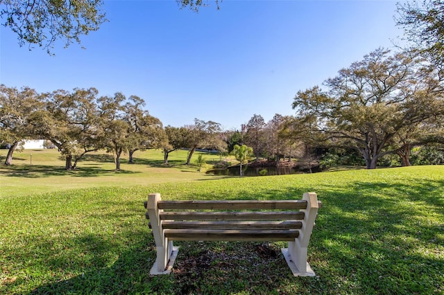 surrounding community with a water view and a lawn