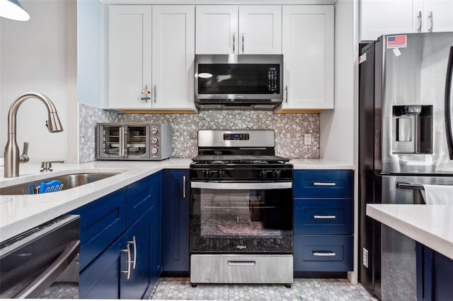 kitchen featuring blue cabinets, sink, tasteful backsplash, white cabinetry, and stainless steel appliances