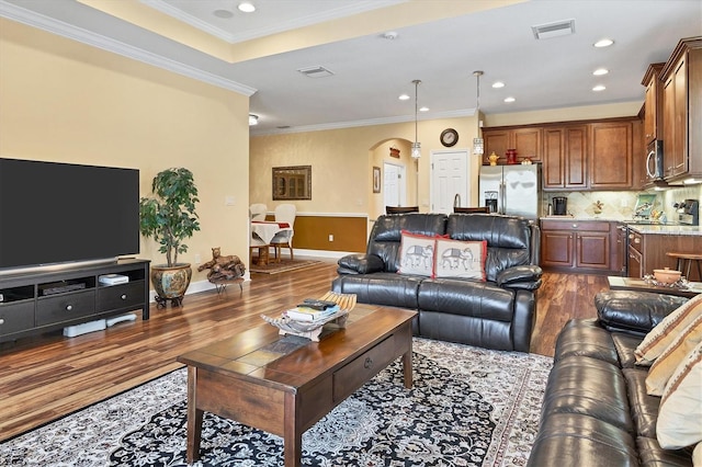 living room with wood-type flooring and ornamental molding