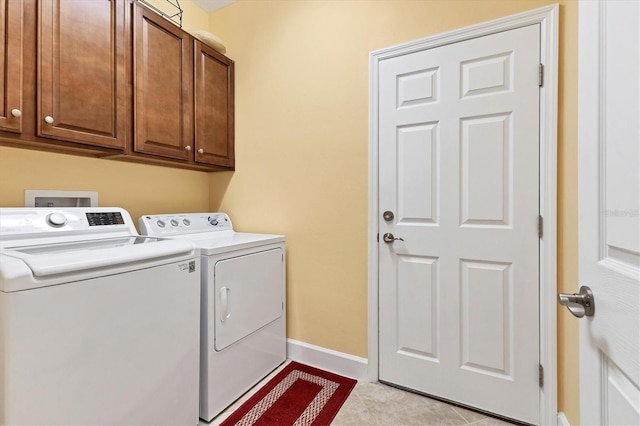 laundry room with light tile patterned floors, cabinets, and independent washer and dryer