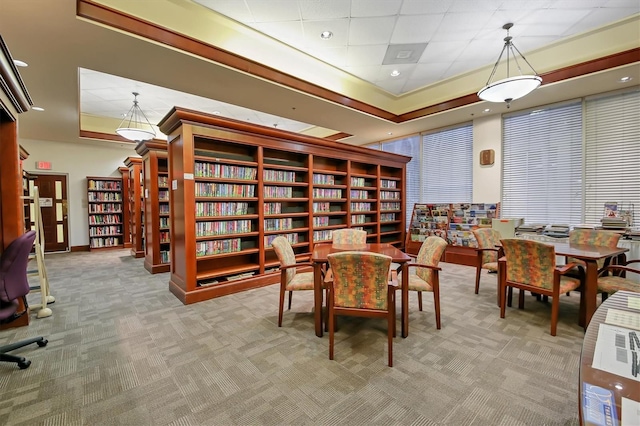 dining space featuring light colored carpet and a tray ceiling