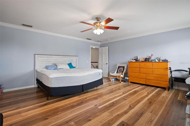 bedroom featuring ornamental molding, wood-type flooring, and ceiling fan