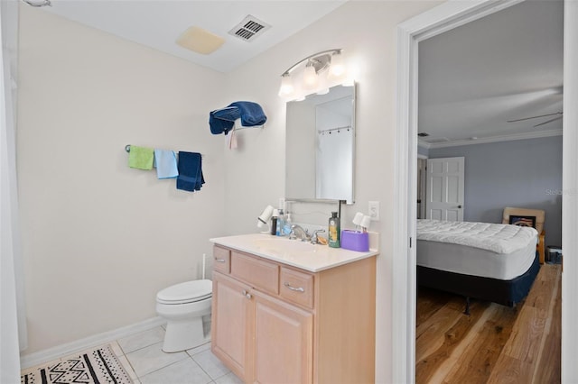 bathroom with vanity, crown molding, toilet, and tile patterned floors