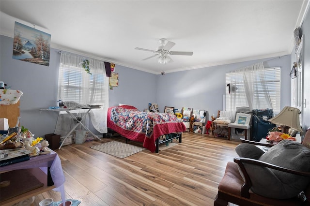 bedroom featuring ornamental molding, light wood-type flooring, and ceiling fan