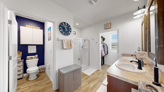 bathroom featuring vanity, hardwood / wood-style flooring, a shower with shower door, and toilet