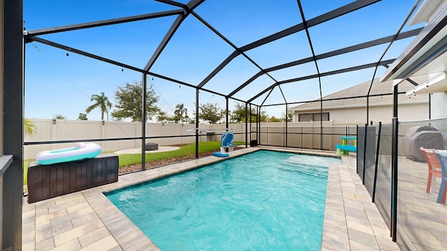 view of pool with a patio and glass enclosure