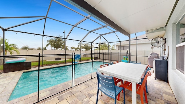 view of swimming pool with glass enclosure and a patio