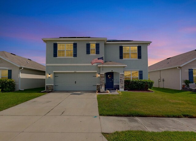 view of front of home with a yard and a garage