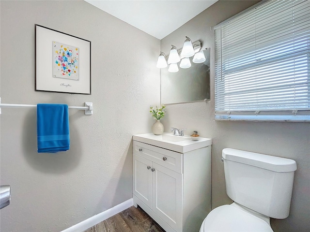 bathroom with hardwood / wood-style floors, vanity, and toilet