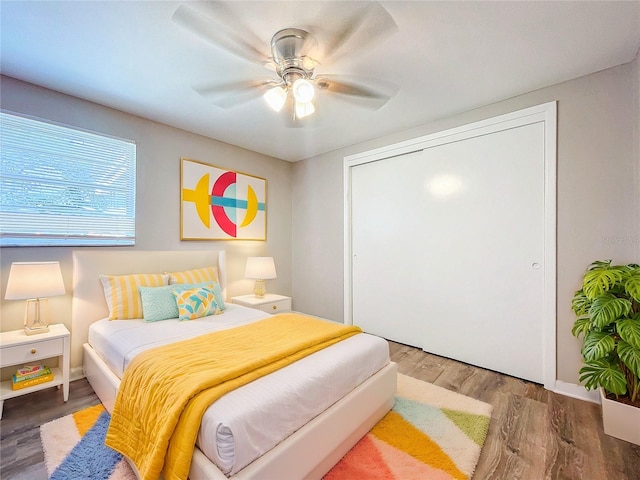 bedroom with ceiling fan, a closet, and wood-type flooring