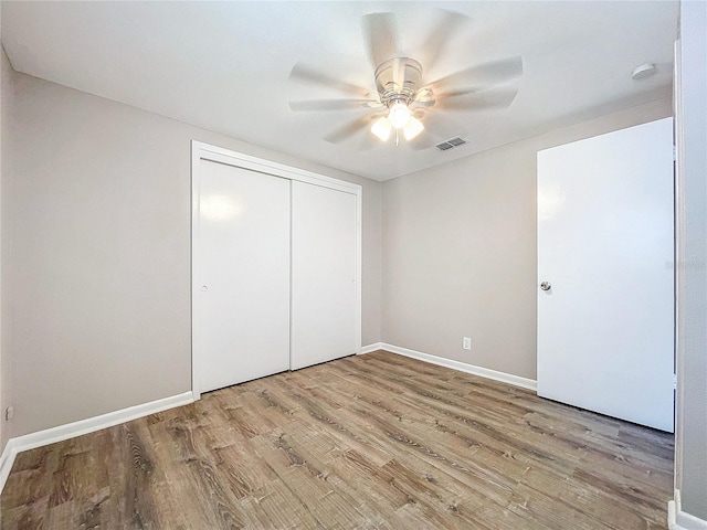 unfurnished bedroom featuring ceiling fan, light hardwood / wood-style flooring, and a closet