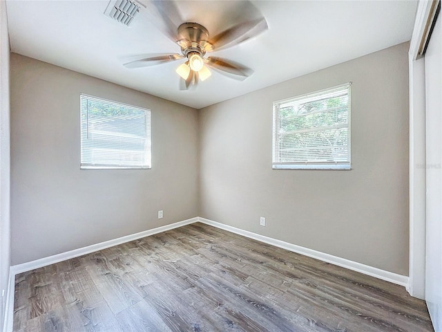 spare room featuring wood-type flooring, ceiling fan, and a healthy amount of sunlight