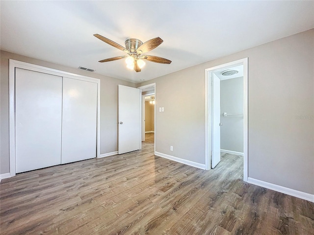 unfurnished bedroom with hardwood / wood-style flooring, ceiling fan, and a closet