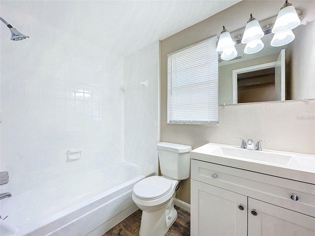 full bathroom featuring vanity, tiled shower / bath, hardwood / wood-style flooring, and toilet