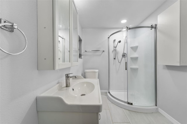 bathroom with walk in shower, vanity, and toilet