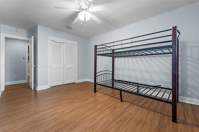 bedroom featuring ceiling fan, hardwood / wood-style flooring, and a closet