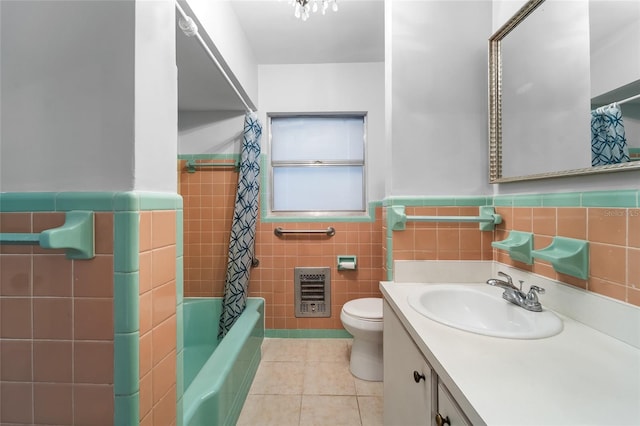 full bathroom with tile walls, shower / bathtub combination with curtain, vanity, toilet, and tile patterned floors