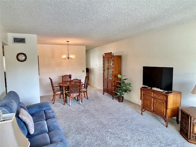 carpeted living room with a textured ceiling and an inviting chandelier