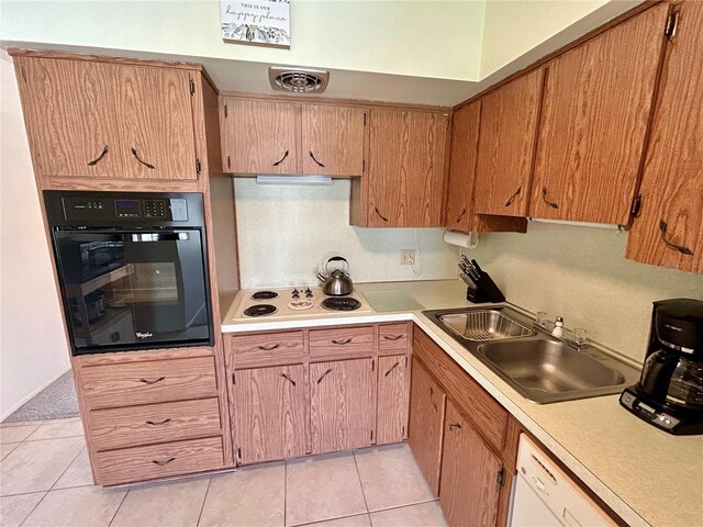 kitchen featuring white appliances, light tile patterned floors, and sink