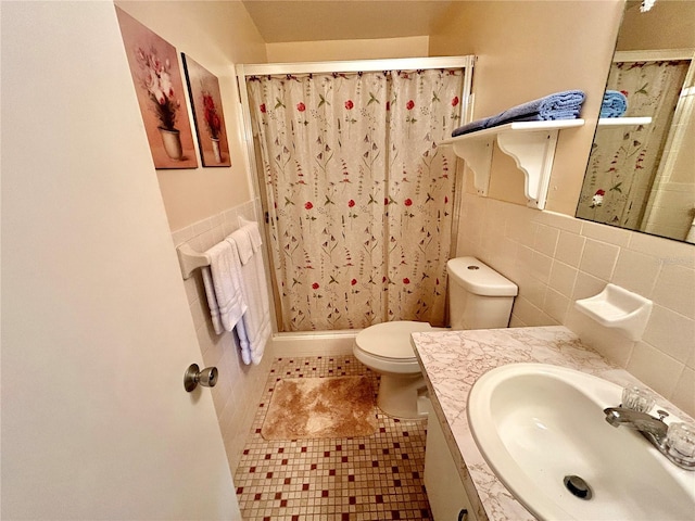 bathroom featuring tile walls, toilet, tile patterned floors, vanity, and curtained shower