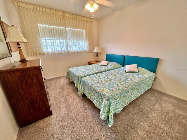 bedroom with ceiling fan and light colored carpet