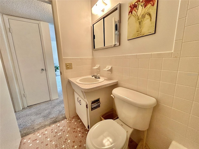 bathroom with vanity, tile walls, and toilet