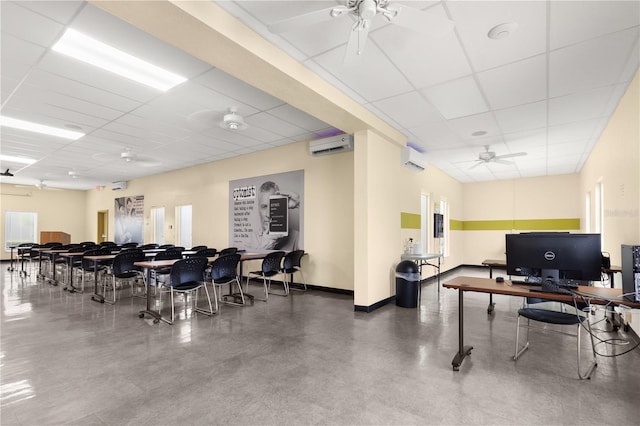 office area featuring ceiling fan, a drop ceiling, concrete flooring, and an AC wall unit